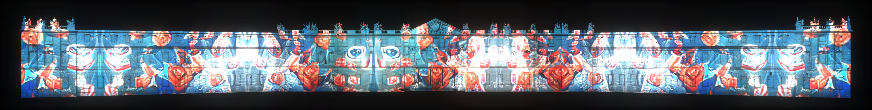 On the facade of the castle in Karlsruhe you can see a projection mapping that glows at night.The mapping shows abstract shapes in red and blue.