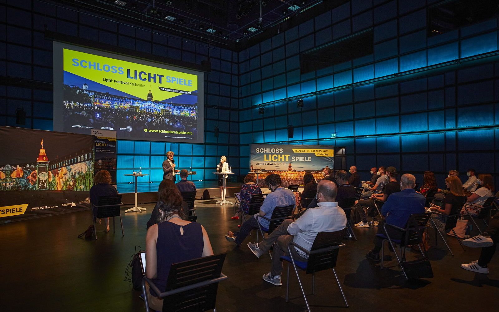 The press conference of the Schlosslichtspiele 2021 in the media theater of the ZKM. Dominika Szope speaks to Lord Mayor Dr. Frank Mentrup, people sit in the audience.