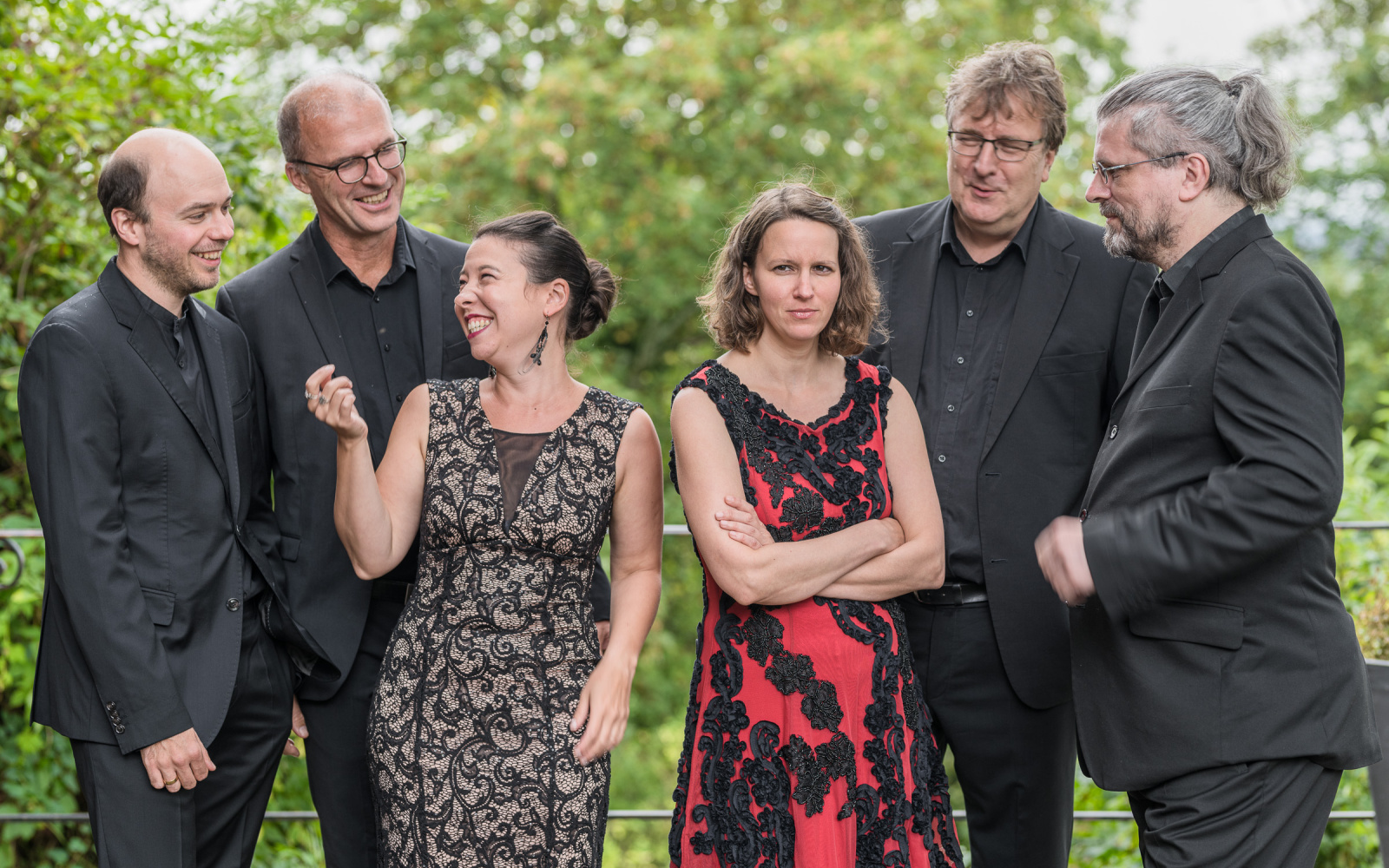 Group portrait of musicians in black evening dress.