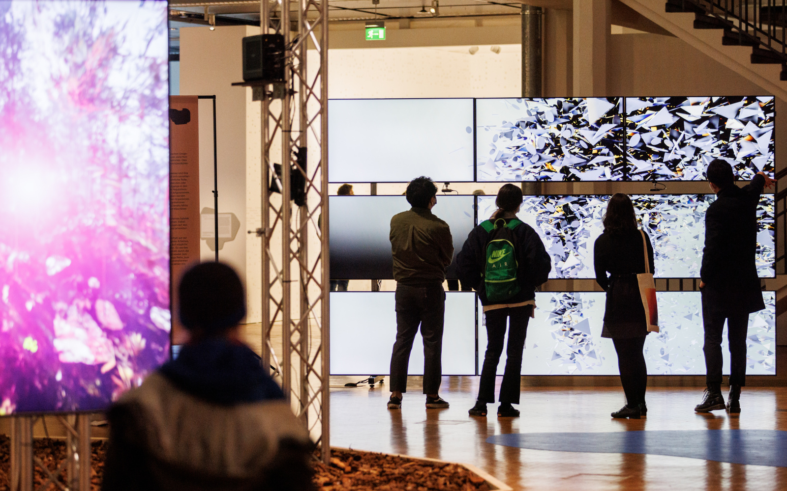 Random International, »Algorithmic Swarm Study (Triptych) / ll«, 2021. The picture shows people in front of a large screen in the BioMedia exhibition.