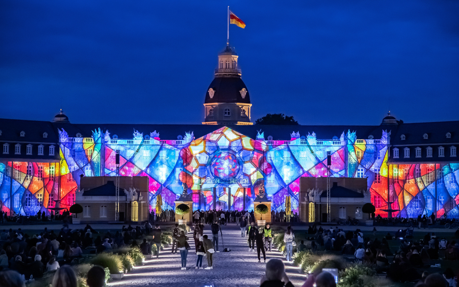 Foto eines bunten Projection Mappings bei Nacht auf dem barocken Karlsruher Schloss.