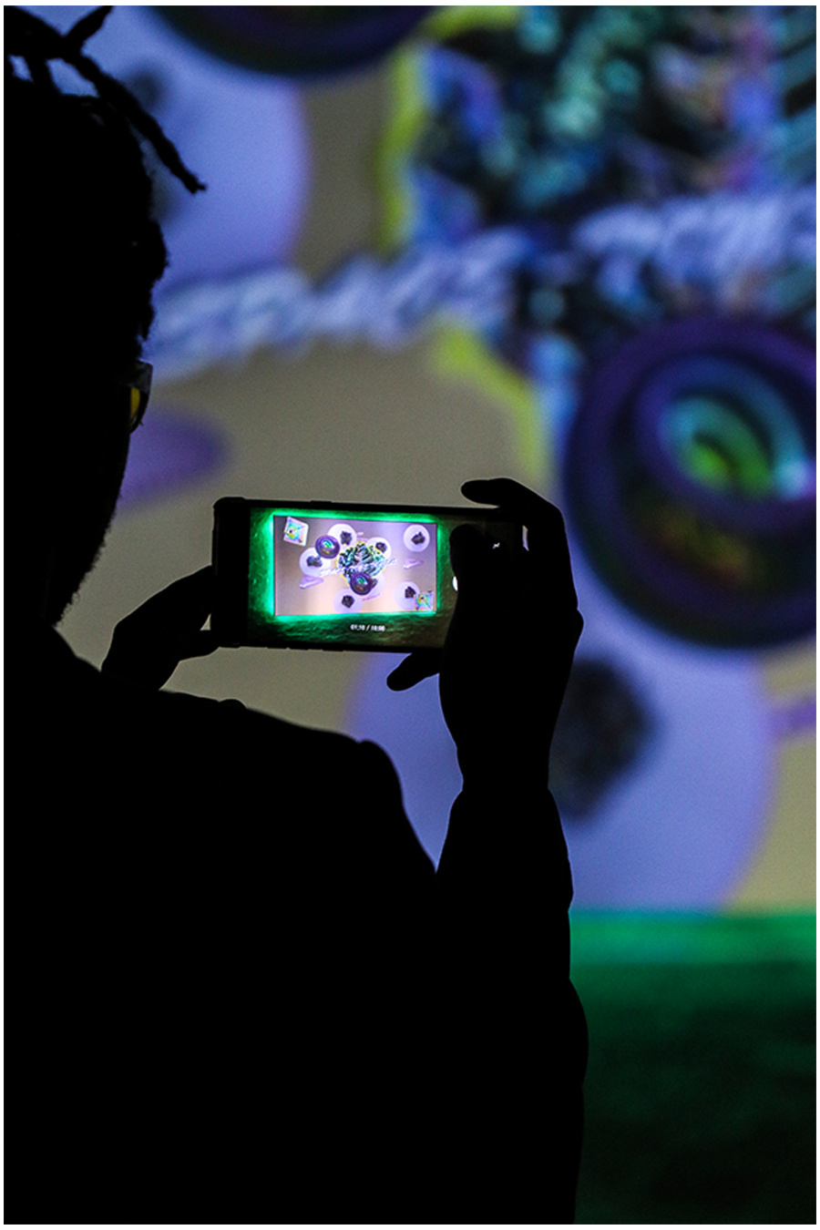 Zu sehen ist eine Person mit einem Smartphone in der Hand, die ein Foto von einem Kunstwerk aufnimmt. 