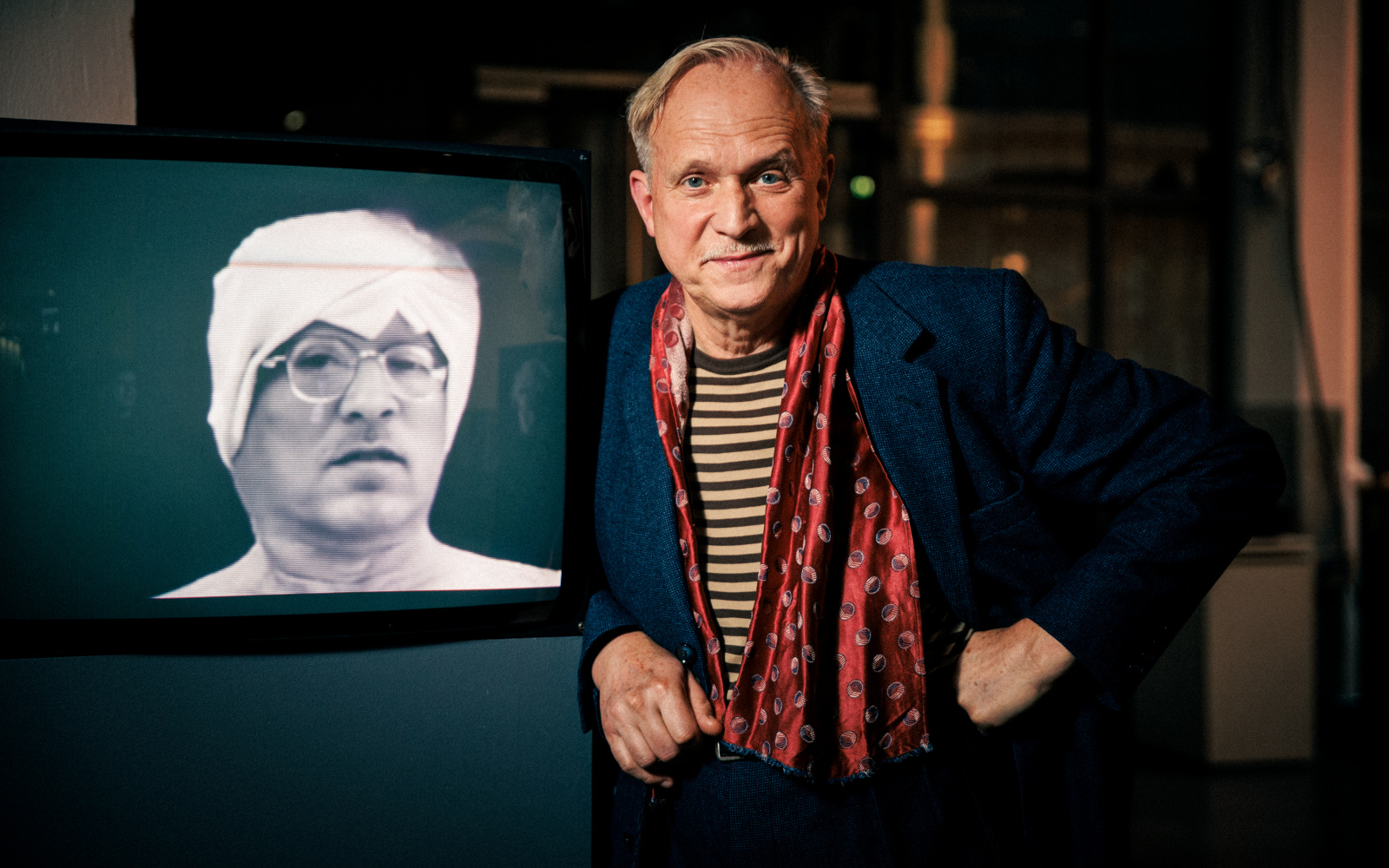 Zu sehen ist ein Mann, der neben einem Röhrenfernseher steht in der Ausstellung »Katharina John: Talking Heads« am ZKM | Karlsruhe, 2022.