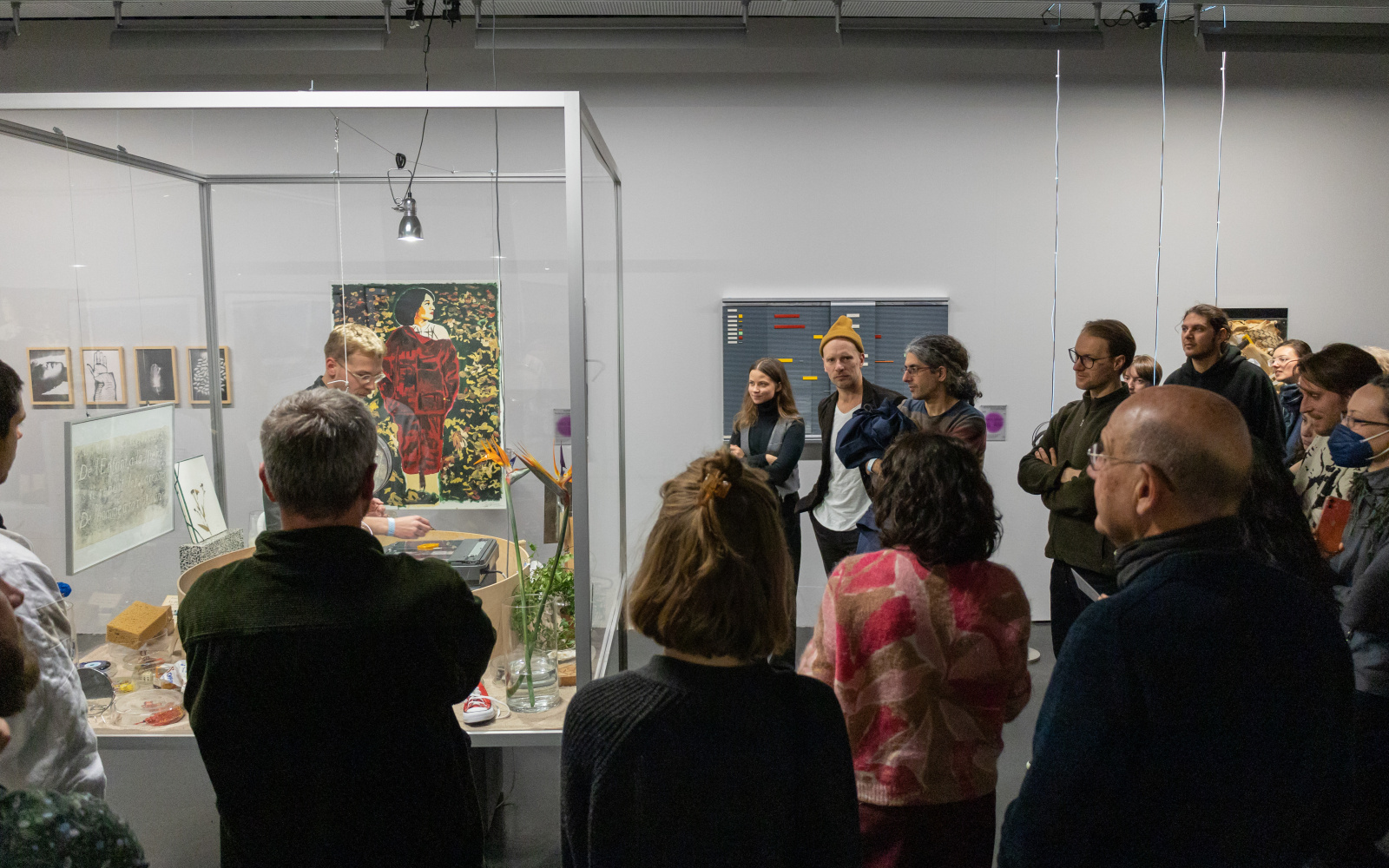 Exhibition view »Matter. Non-Matter. Anti-Matter« at ZKM | Center for Art and Media Karlsruhe, 2022. Several people gather around a glass box, in which different objects lie.