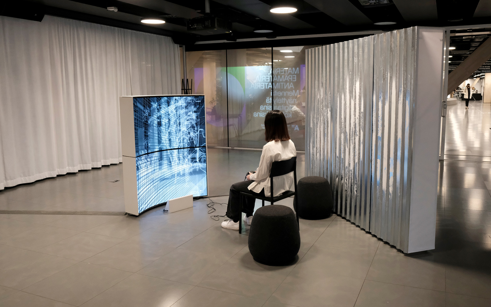 You can see a person sitting in front of an immaterial display. 