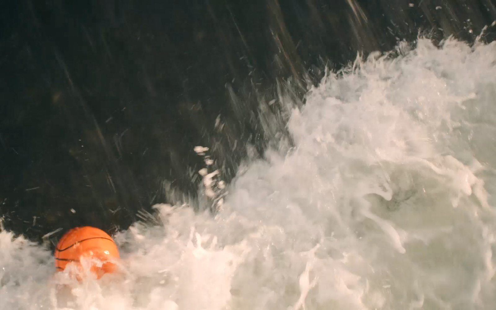 You see a basketball in the water of a fountain.