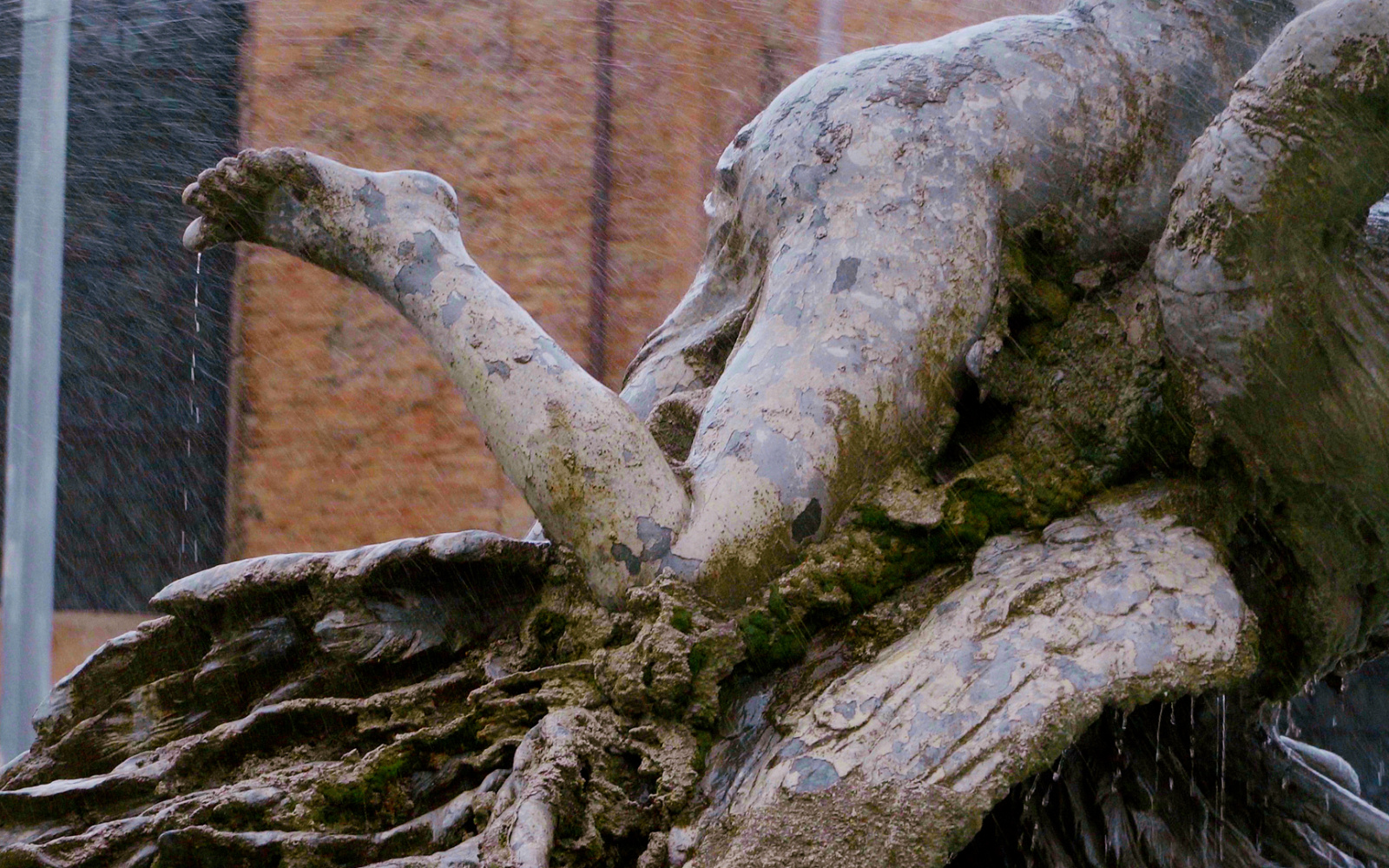 Man sieht das Hinterteil einer Wasserstatue im Brunnen.