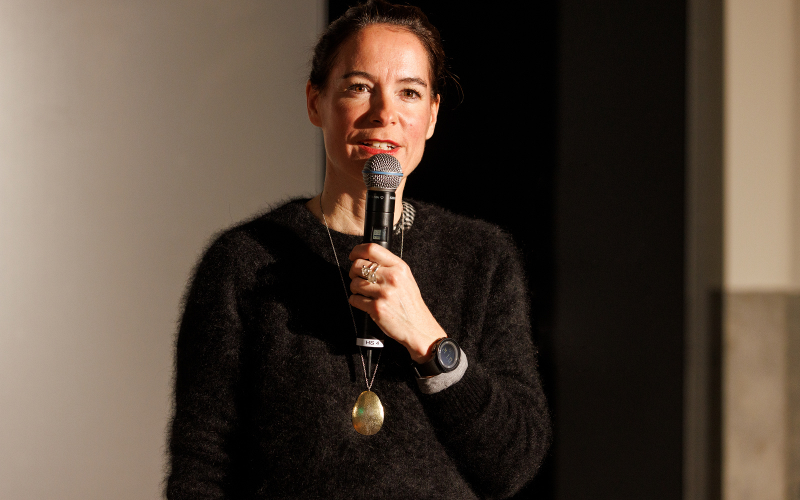 A person with a microphone is seen at the opening of the exhibition »Repairing the Present :RETOOL« 