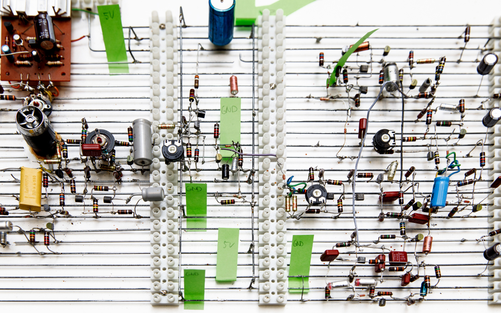 Blick auf eine Gitterstruktur mit Kondensatoren und anderen elektronischen Elementen.