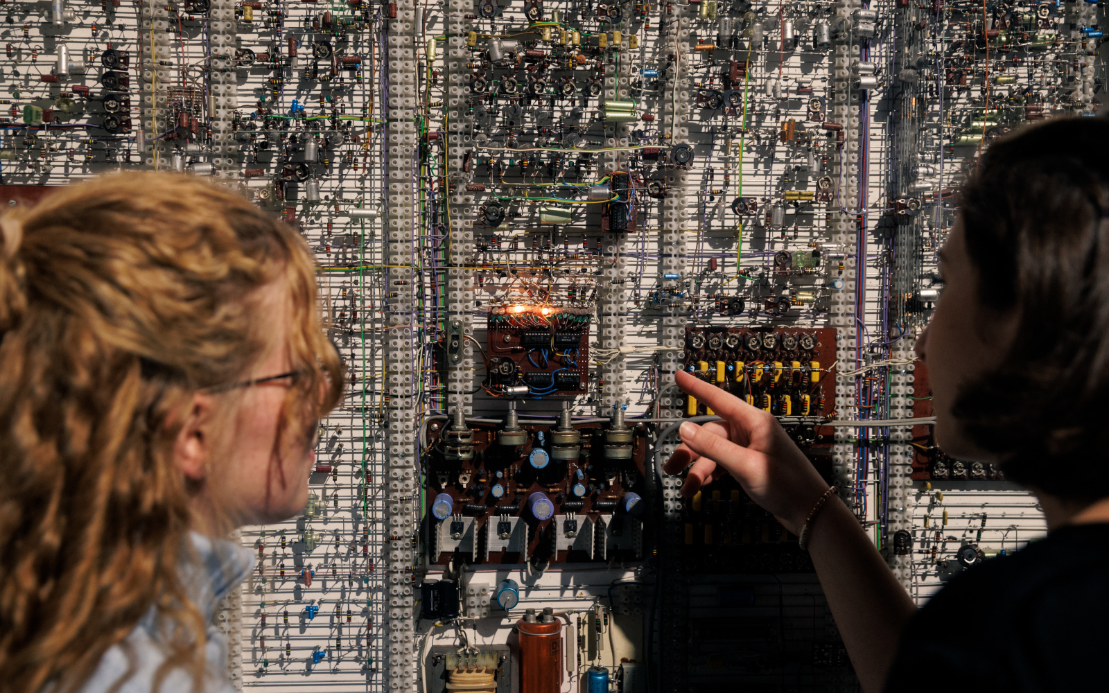 Exhibition view »Walter Giers. Electronic Art«You can see two people looking closely at an installation by Walter Giers. 