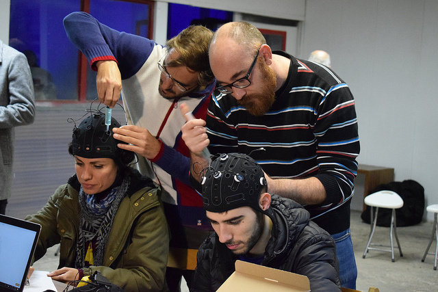 Das Bild zeigt Workshopteilnehmende beim Anbringen von Kopfsensoren.