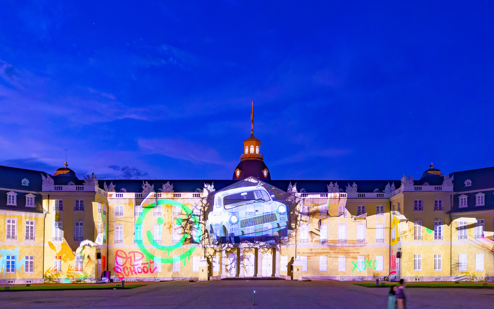 Ein Auto durchbricht scheinbar die Fassade des Karlsruher Schlosses.