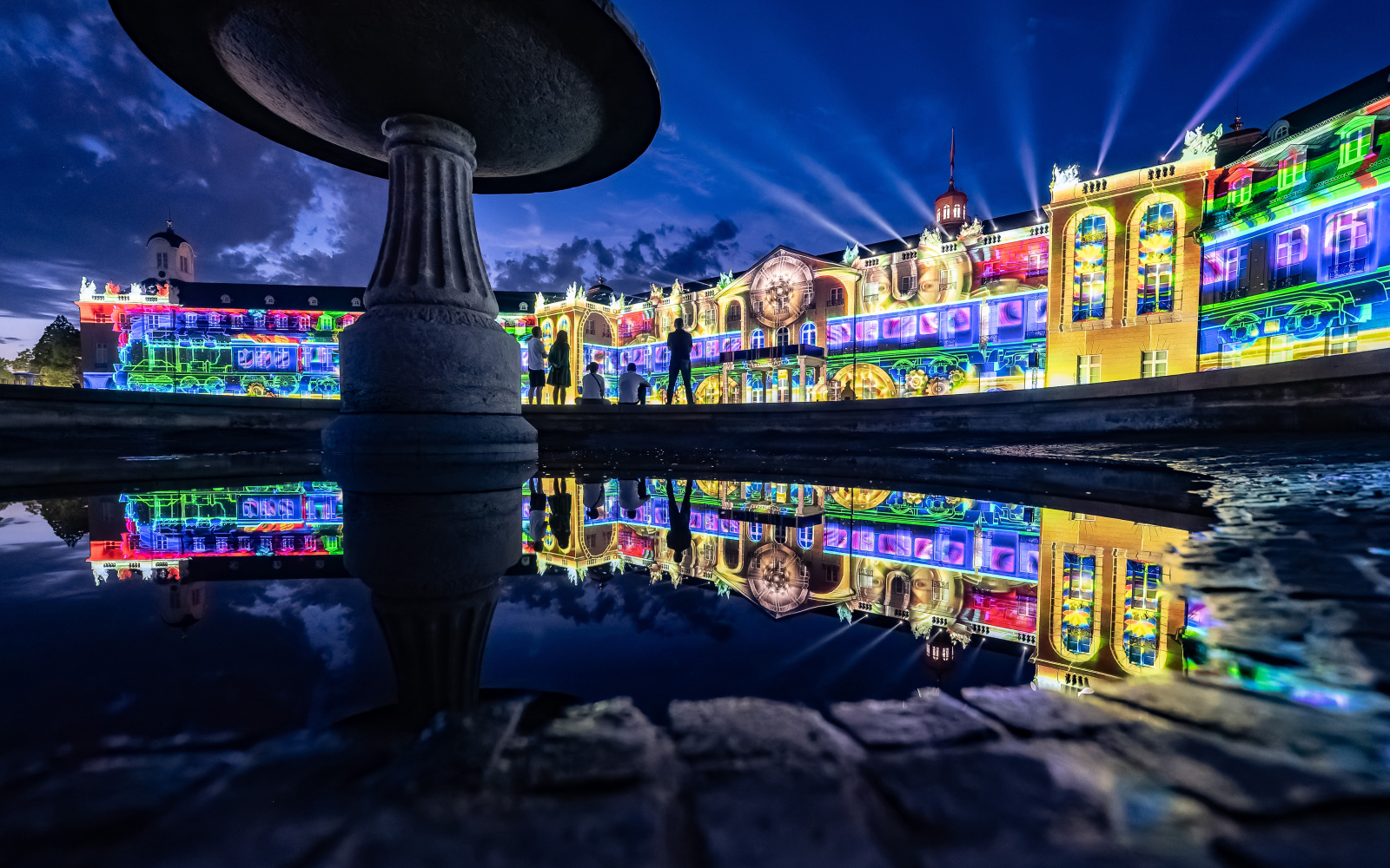 On view is the winning entry of the BBBank Award 2023 "BhinnekaExpress", 2023, The Fox, The Folks (Indonesia). The fountain in front of the castle can be seen in the foreground and the colourful facade of the castle in the background.
