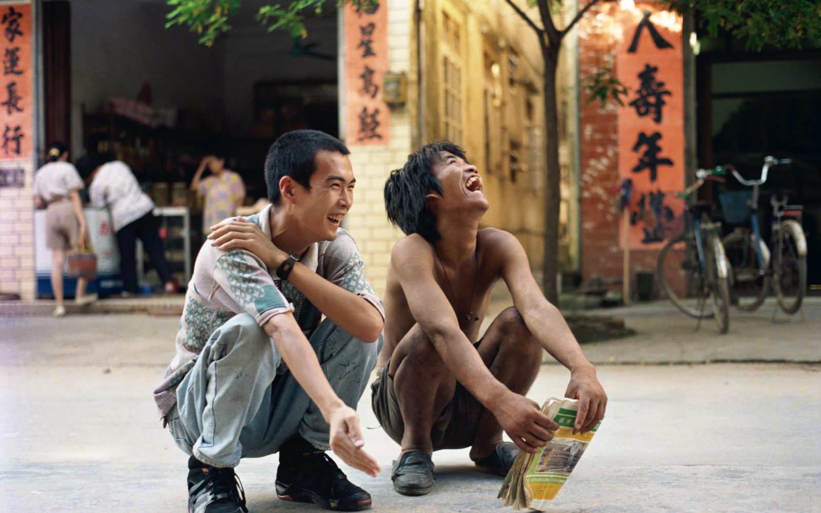 Two men crouching and laughing in China