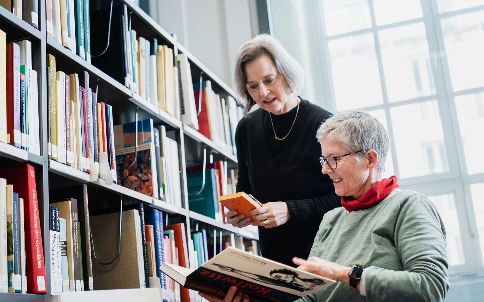 Zwei Frauen beim Einsortieren von Büchern.