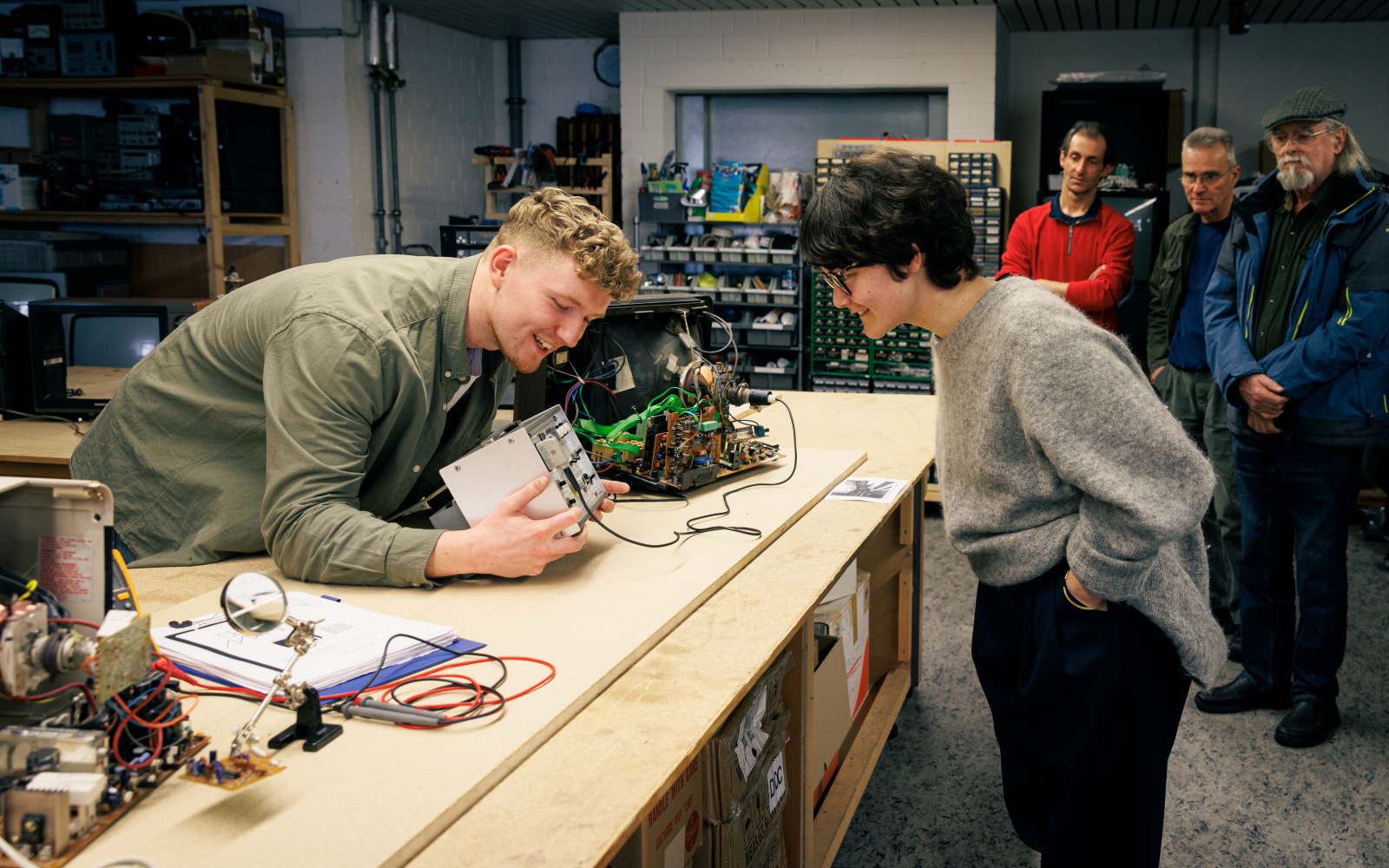 Two people examine a CRT screen.