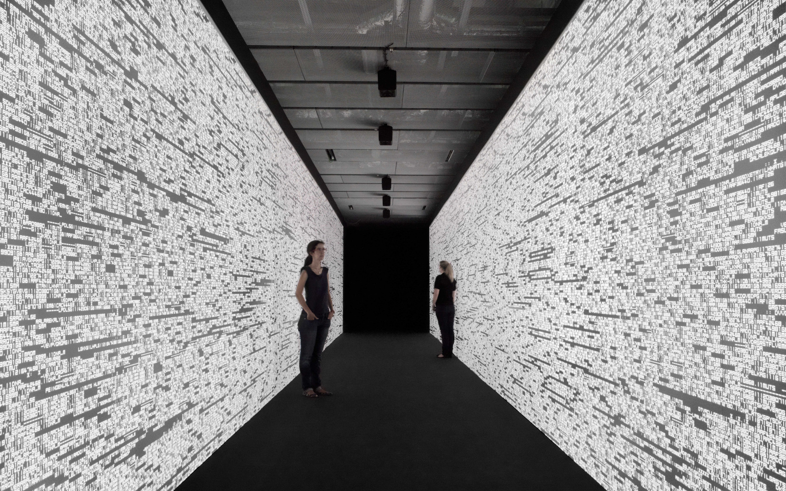 Two women in a corridor. The walls are made out of numbers.
