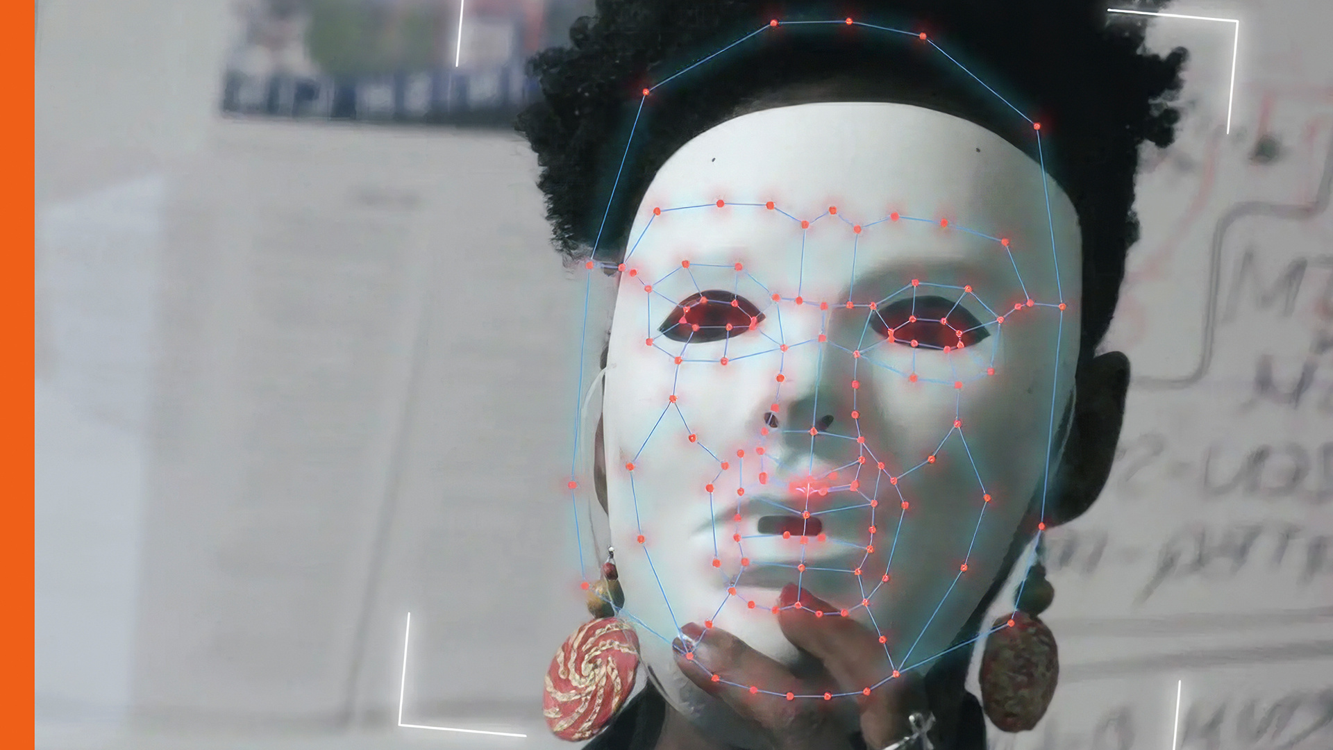 Eine schwarze Frau mit weißer Maske vor dem Gesicht. Die Maske scheint gerade von einem Computer gescannt zu werden.
