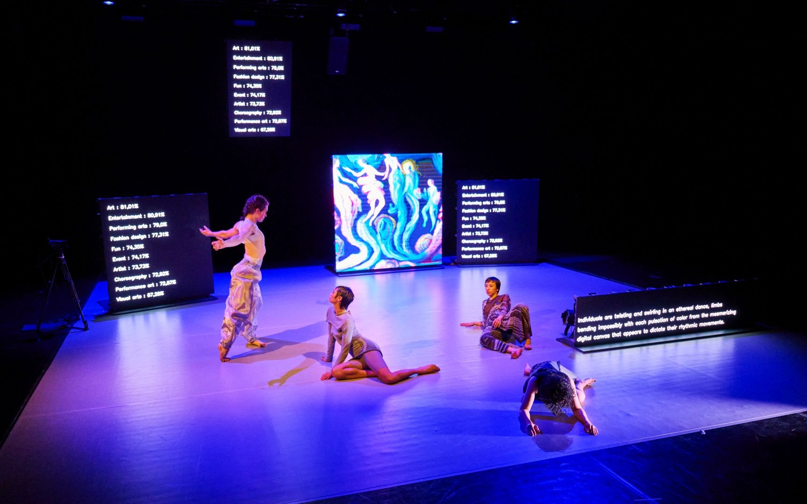 Four people can be seen on a stage. 
