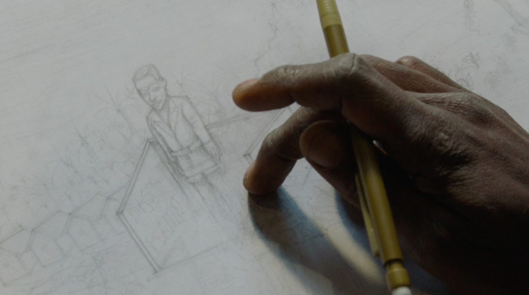 You can see a detailed view of a hand working on a picture with a pen.