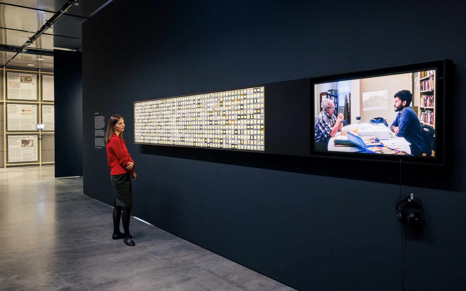You can see a person looking at a wall full of slides. 