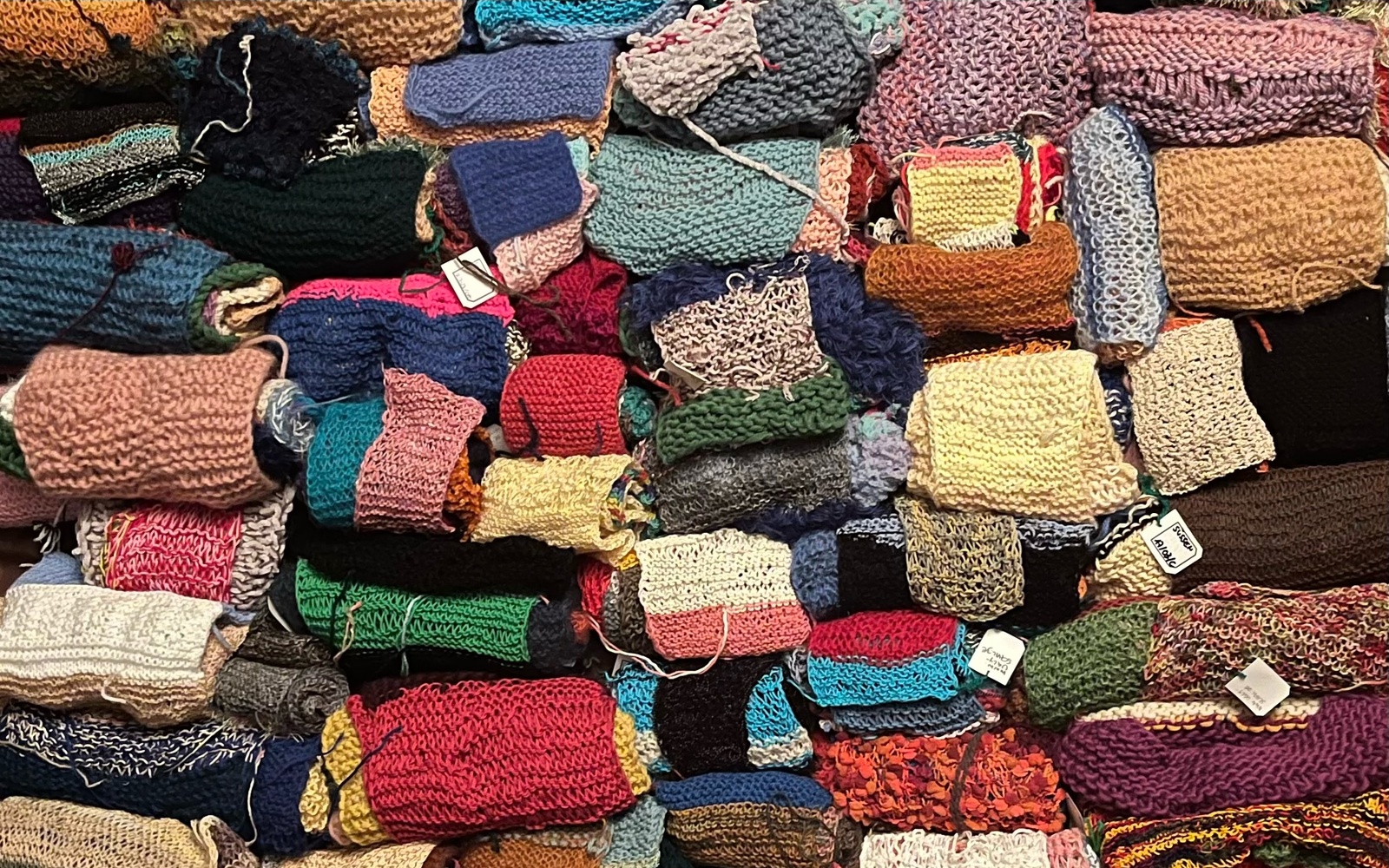 You can see various scarves stacked on top of each other.