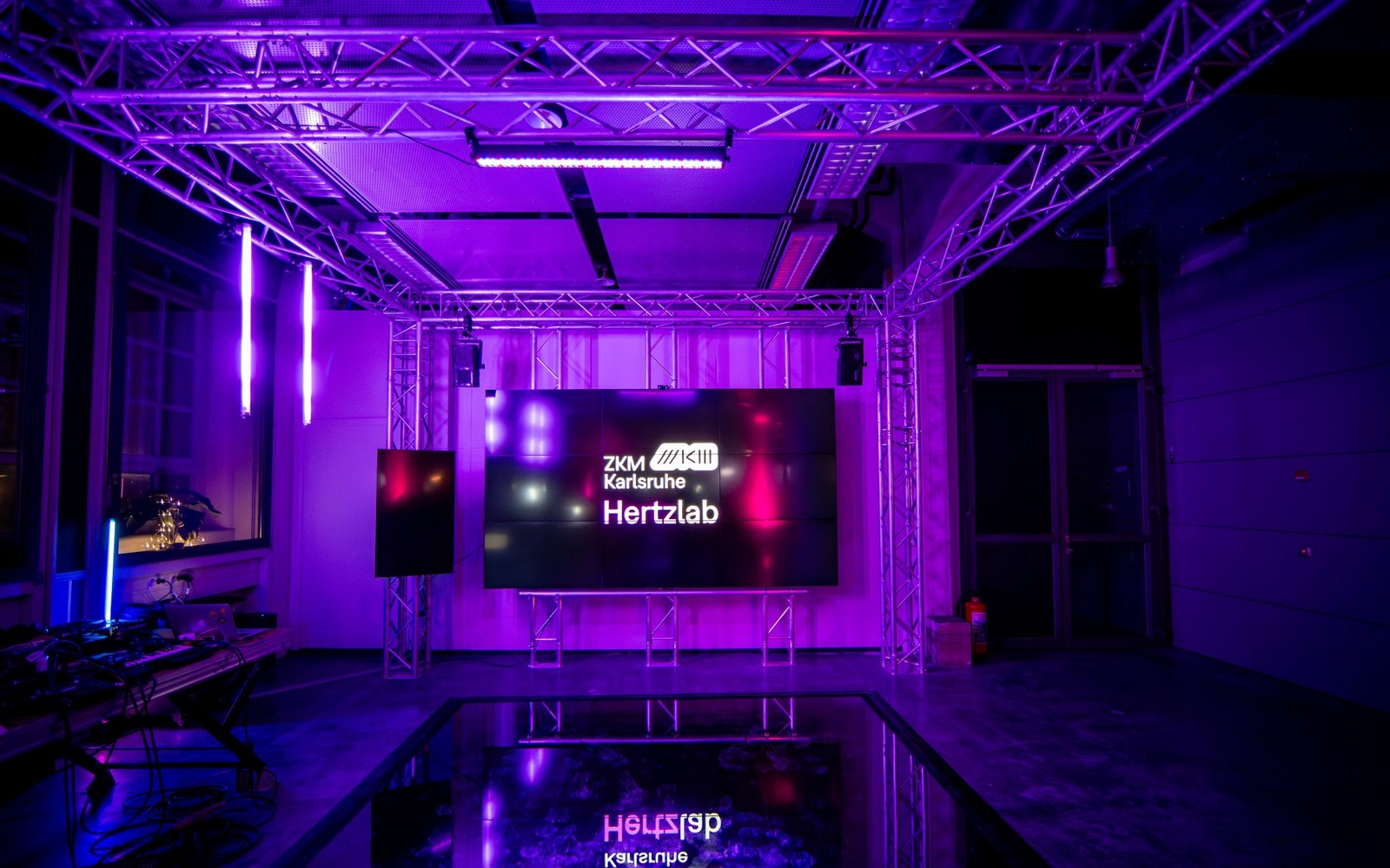 A screen of the Hertz laboratory is located in a purple-lit room.