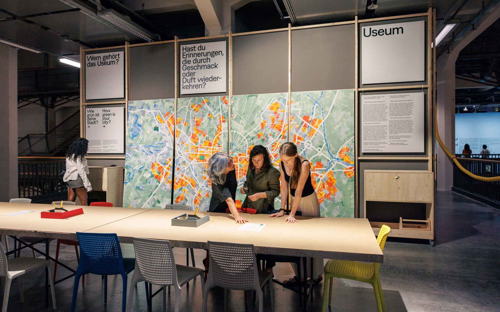 Drei Frauen schauen auf Zettel im USEUM Space des ZKM