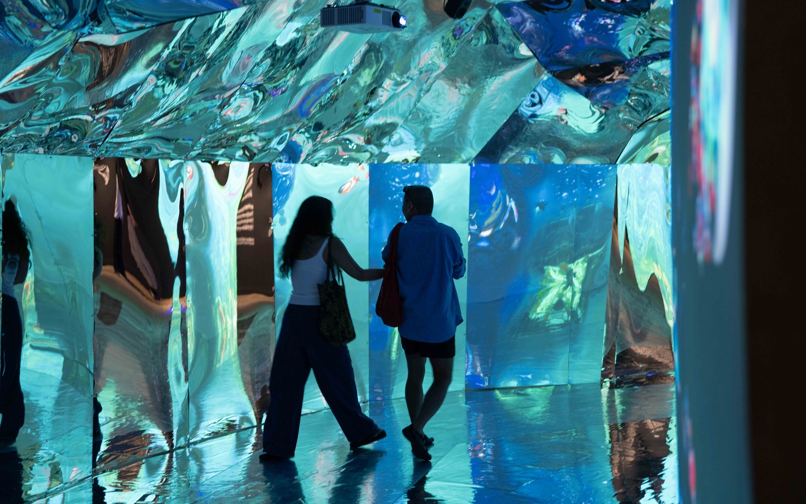 Two people in a turquoise cave passageway