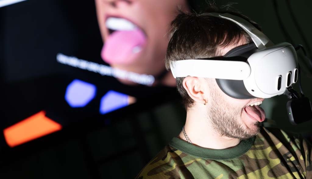 Bild einer Person mit VR-Brille. Die Person streckt ihre Zunge heraus. 