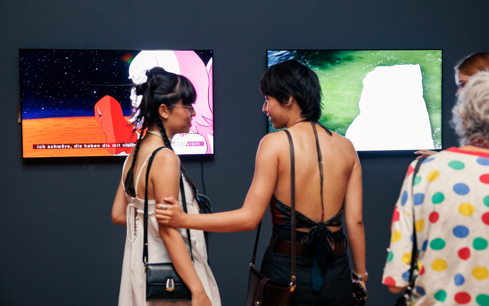 Zwei Personen stehen vor zwei Bildschirmen.