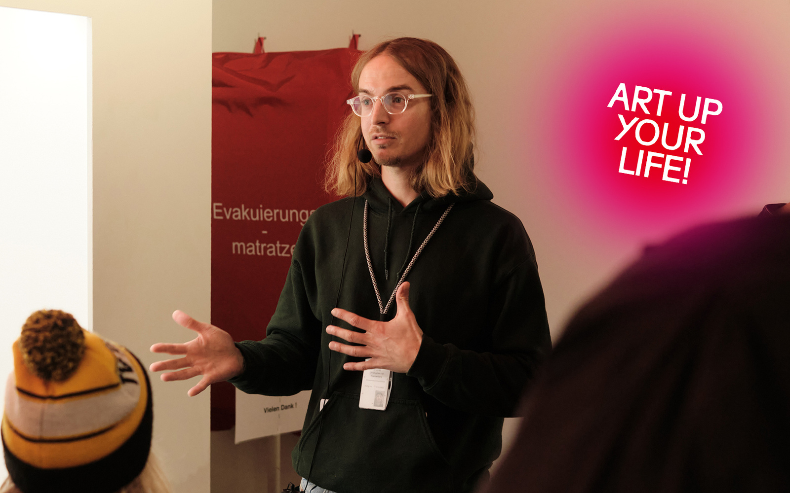 Eine Person steht vor anderen Personen und gestikuliert.