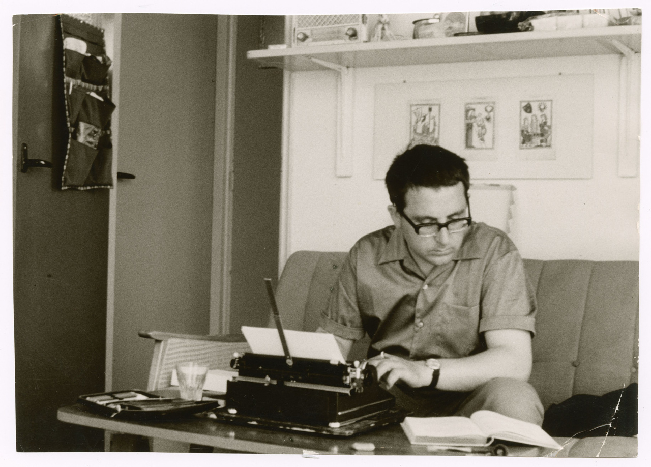 Theo Lutz sitz in einem Arbeitszimmer auf der Couch und arbeitet an der Schreibmaschine.