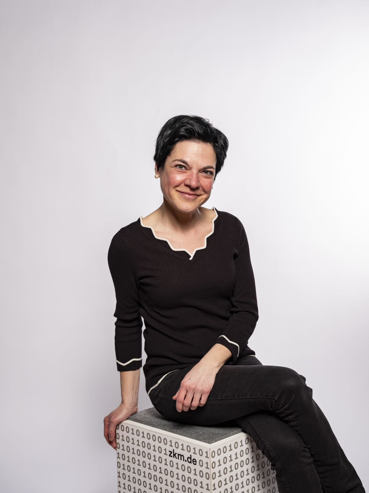 smiling seated woman with short black hair