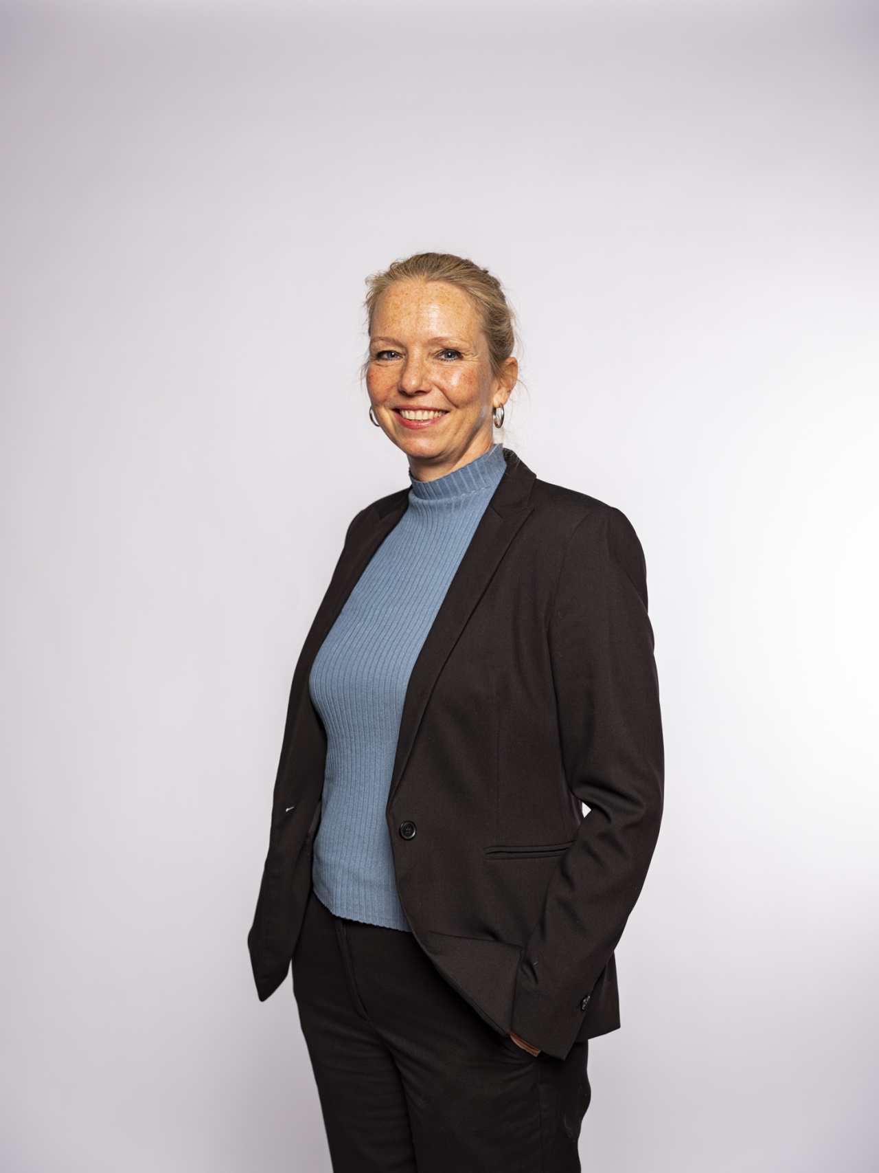 standing smiling woman with blond hair