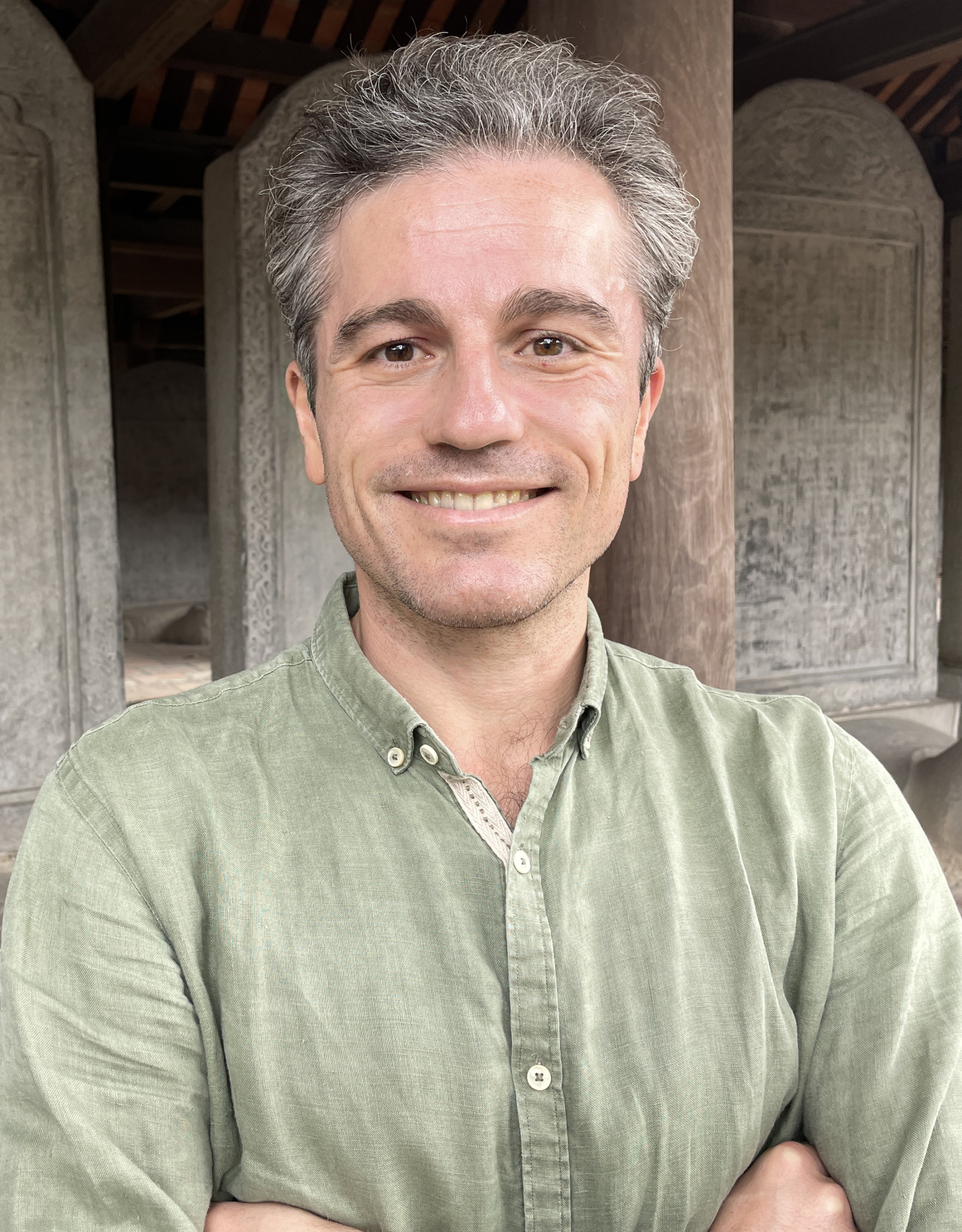 A man in a green linen shirt with short gray hair