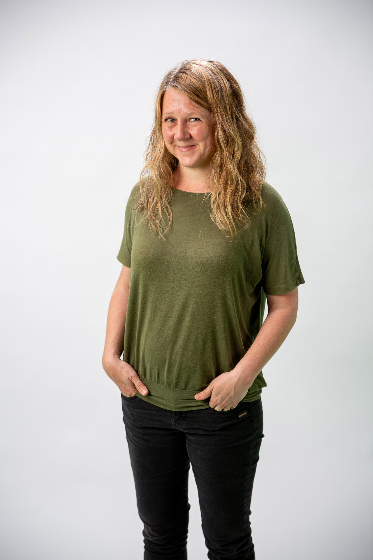 Eine Frau mit blonden Locken und grünem TShirt