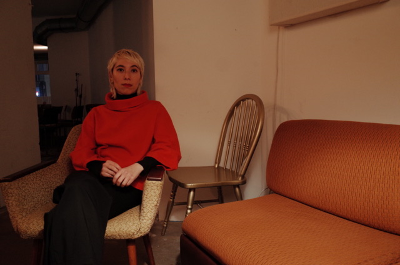 The picture shows a portrait photo of a person sitting on a chair.