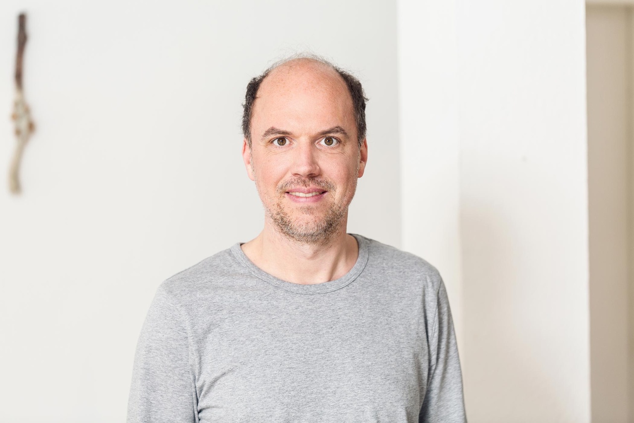 Porträt einer Person vor weißem Hintergrund.