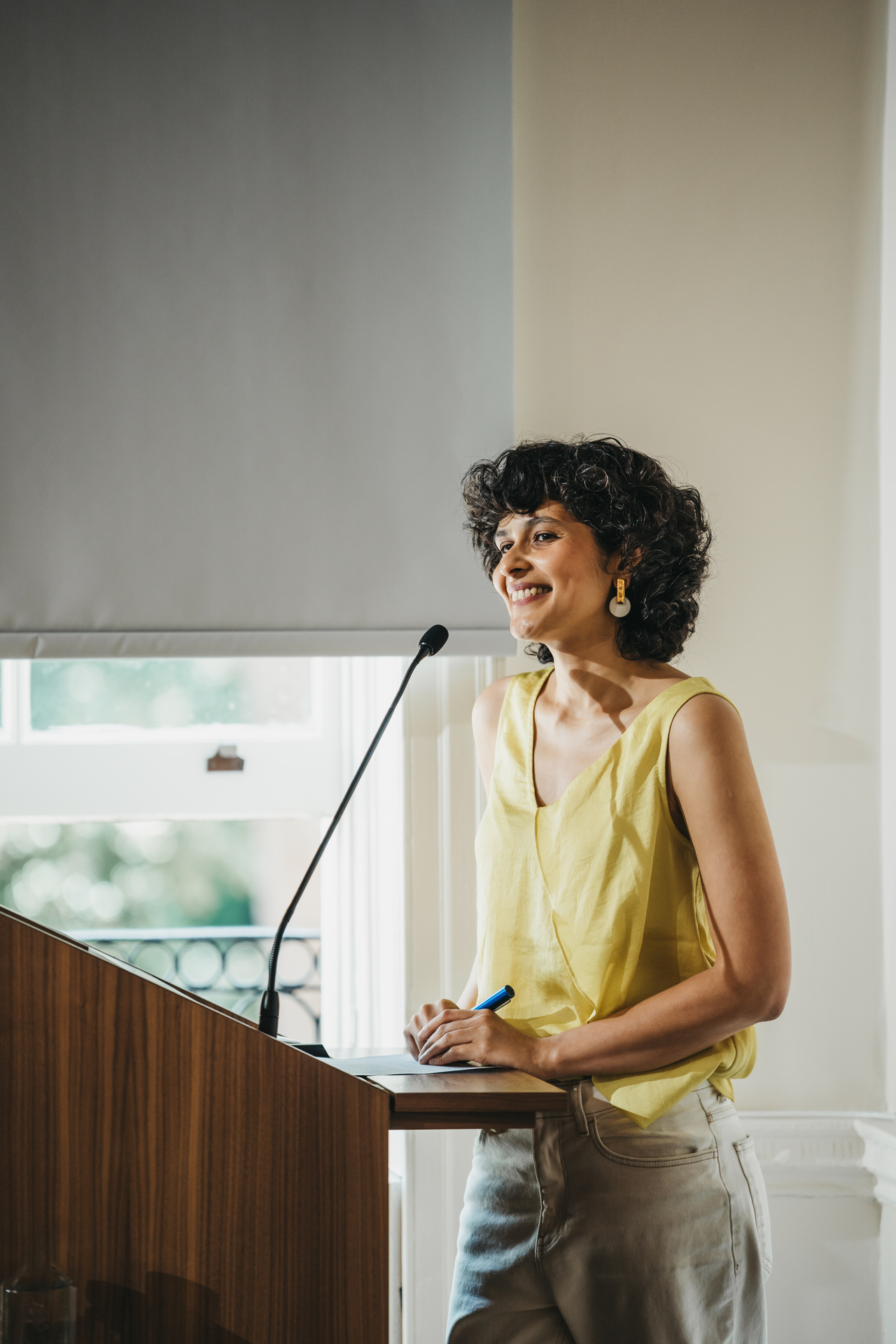 A portrait photograph of a person standing at a lectern.