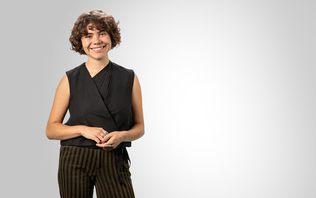 A person stands in front of a white background.