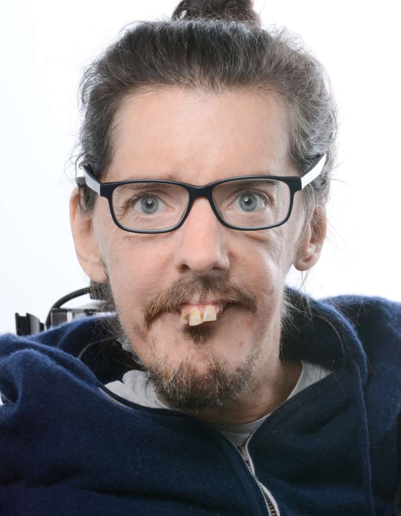 Portrait einer Person vor weißem Hintergrund.