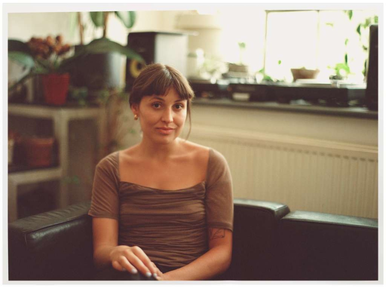 Portraitfoto einer Person auf einem Sofa sitzend.