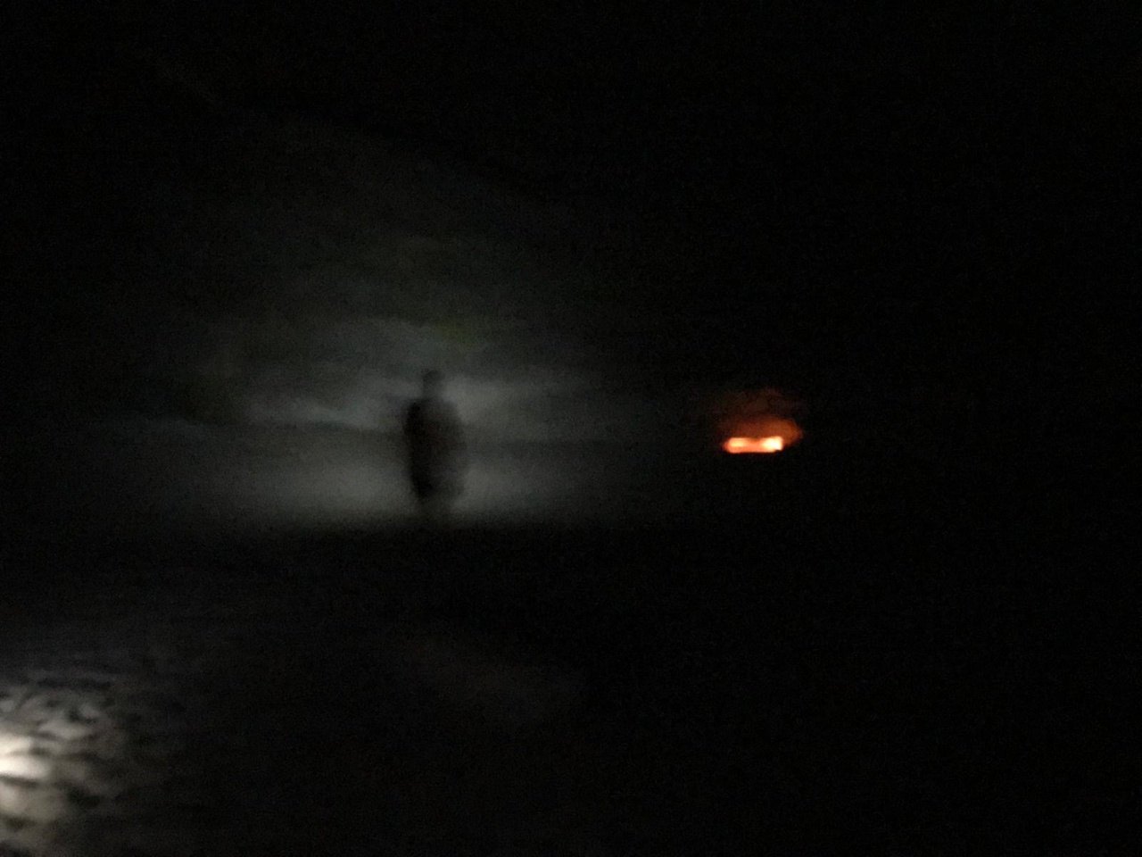 Im Dunkeln ist die Silhouette einer Person zu sehen. 