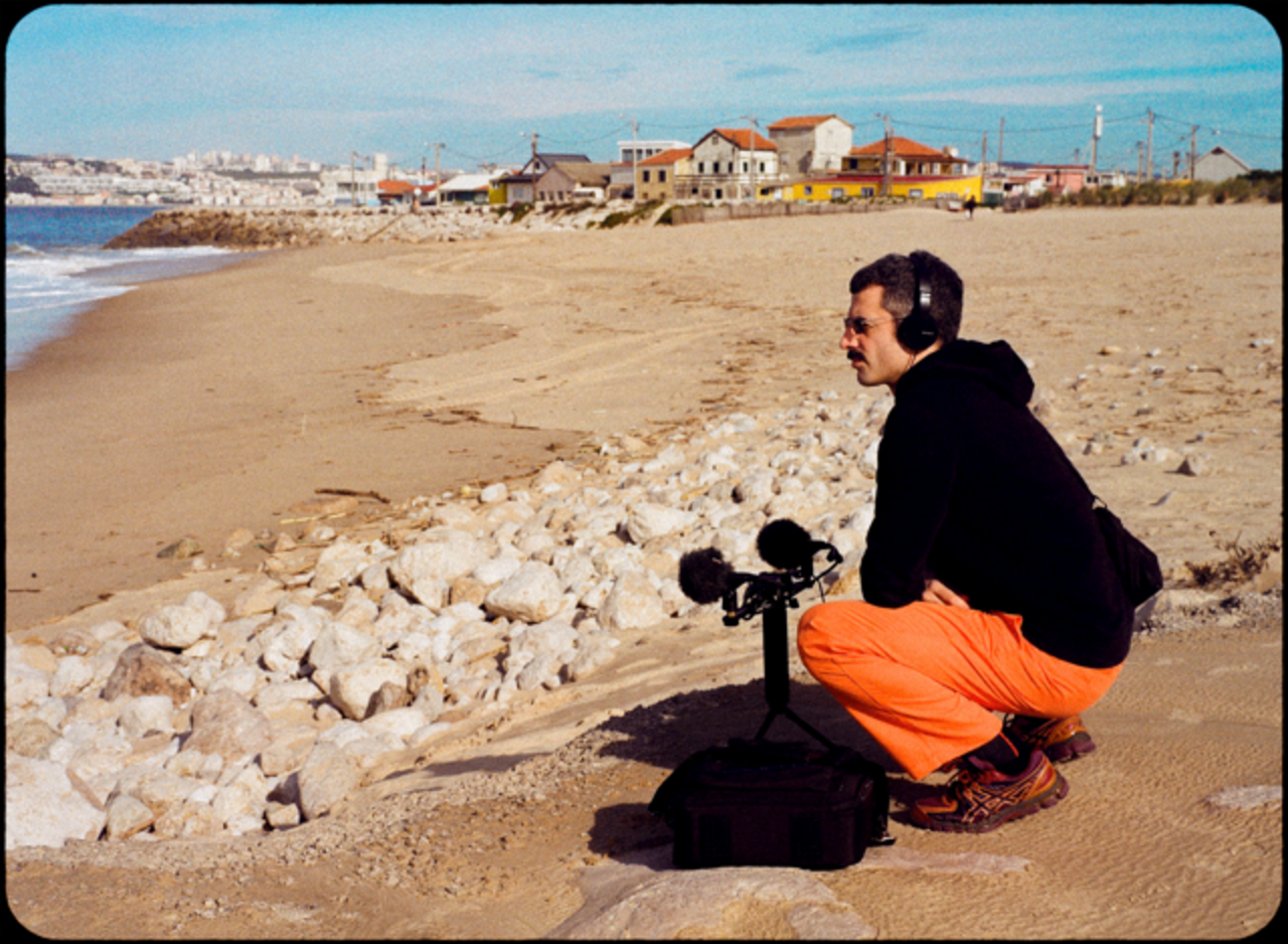 Zu sehen ist eine Person, die am Strand Geräusche aufnimmt. 