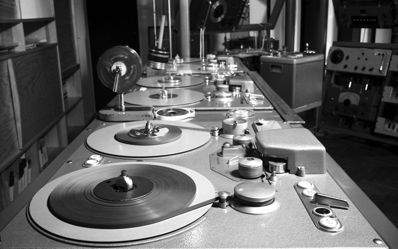 The black and white image shows an old mixing console. 