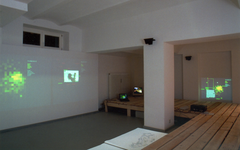 View of the exhibition space of the gallery K & S: In a space architecture made of pallets maps, pictures and films are projected.