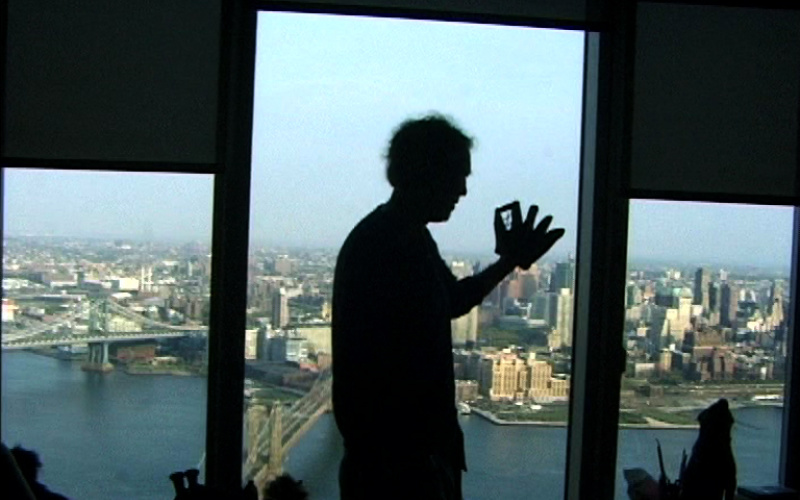 A skyline as a triptych in color. Before that, a man in profile view as a silhouette.