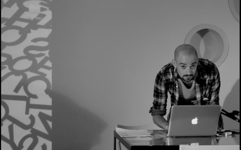 B/W photography. A man uses a laptop standing on a table.