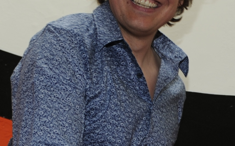 A laughing man wearing a blue shirt.